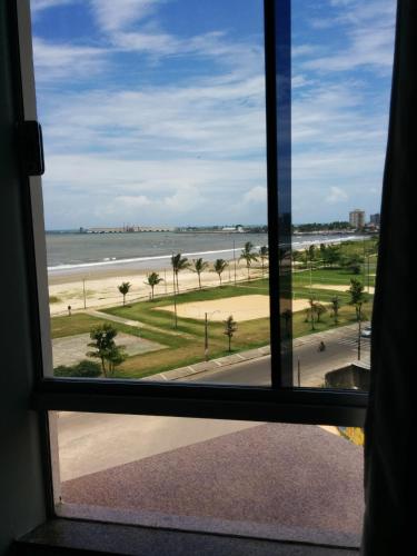 a window view of the beach from a hotel room at Barravento Praia Hotel in Ilhéus