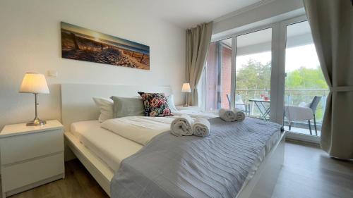 ein Schlafzimmer mit einem Bett mit zwei Handtüchern darauf in der Unterkunft Strandhaus Nordseebrandung Fewo A3.3 in Cuxhaven