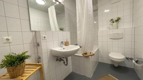 ein weißes Bad mit einem Waschbecken und einem WC in der Unterkunft Strandhaus Nordseebrandung Fewo A3.3 in Cuxhaven