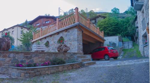 a small red car parked next to a building with a balcony at Ca' di Pazient in Teglio