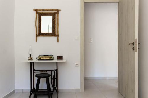 a room with a table and a mirror and a stool at Laina Traditional Guest House in Apeiranthos