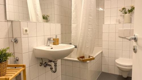 a white bathroom with a sink and a toilet at Strandhaus-Nordseebrandung-Fewo-B2-3 in Cuxhaven