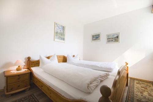 Schlafzimmer mit einem Bett mit weißer Bettwäsche in der Unterkunft Frische Brise 06.01 in Cuxhaven