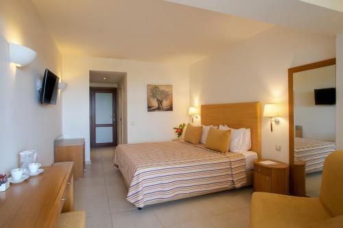 a hotel room with two beds and a television at Blue Sea Beach Affiliated By Melia in Stalida