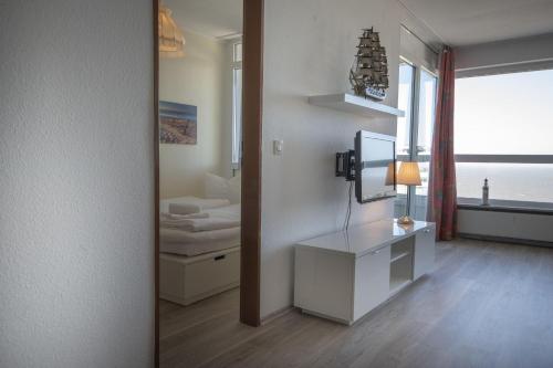 Habitación con espejo, escritorio y cama. en Frische-Brise-15-09, en Cuxhaven