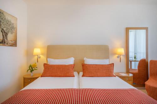 a bedroom with a bed with two orange pillows at Blue Sea Beach Affiliated By Melia in Stalida