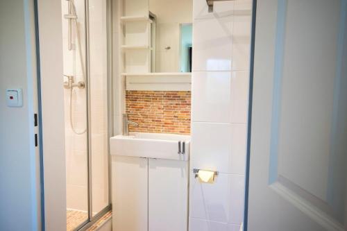 ein weißes Badezimmer mit einem Waschbecken und einem Spiegel in der Unterkunft Haus Frauenpreiss - Ferienwohnung 57 in Cuxhaven