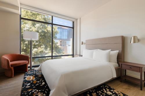 1 dormitorio con cama blanca y ventana grande en Sonder at Pivot en Seattle