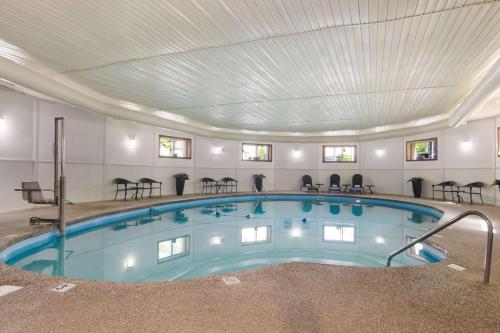 a large indoor pool with chairs and tables at Best Western Plus Traverse City in Traverse City