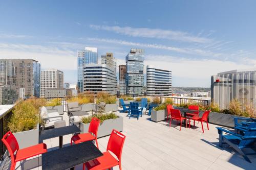 a rooftop patio with tables and chairs and a city skyline at Sonder at Pivot in Seattle