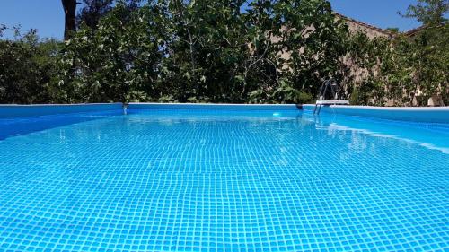 a large blue swimming pool with a chair in it at Domaine de la Matte in Conques-sur-Orbiel