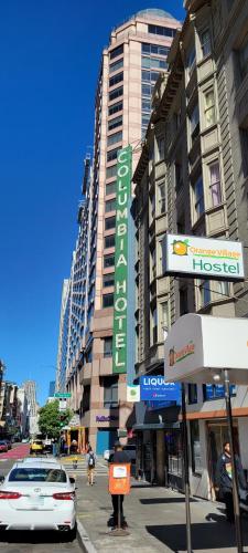 a city street with cars parked in front of a building at Orange Village Hostel in San Francisco