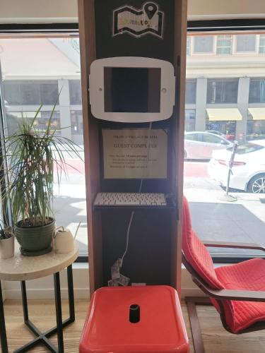 a computer sitting on top of a box with a red stool at Orange Village Hostel in San Francisco