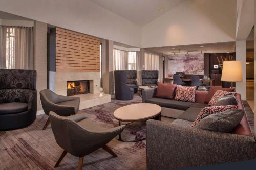 a lobby with couches and chairs and a fireplace at Sonesta Select Columbia in Columbia