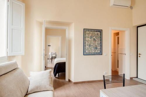 フィレンツェにあるApartments Florence - Ginevraのリビングルーム(ソファ付)、ベッドルーム1室が備わります。