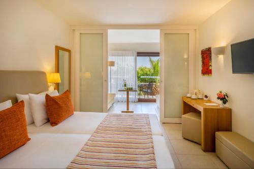 a hotel room with a bed and a living room at Blue Sea Beach Affiliated By Melia in Stalida