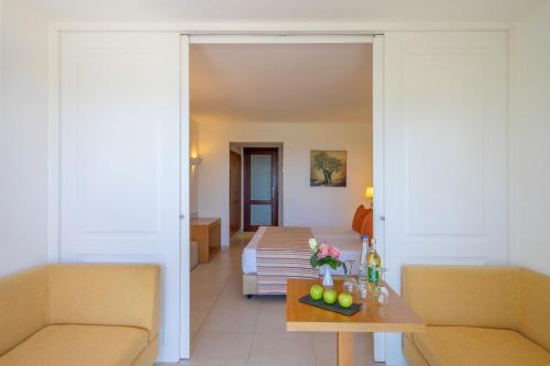a living room with a table and a couch at Blue Sea Beach Affiliated By Melia in Stalida