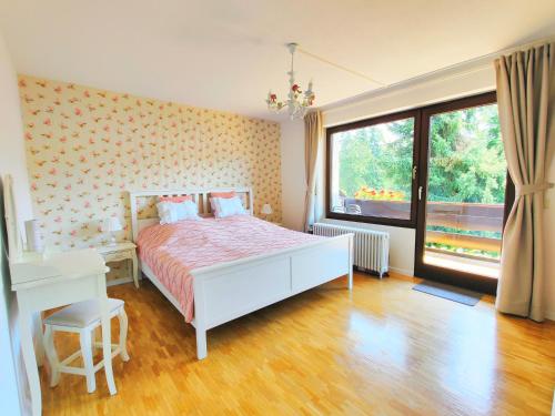 a bedroom with a white bed and a window at Romantic Style Apartment Titisee in Titisee-Neustadt