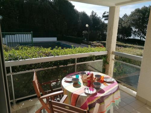 a table with a plate of food on a porch at Appartement Pornic vue mer in Pornic
