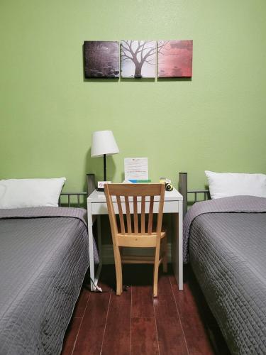 a desk with a chair in a room with two beds at Orange Village Hostel in San Francisco