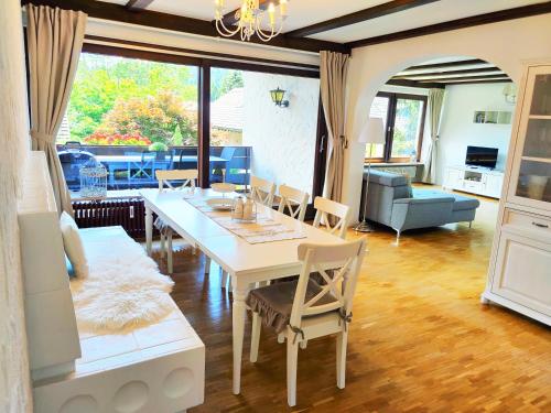 Romantic Style Apartment Titisee في تيتيسي نيوستادت: غرفة معيشة مع طاولة وكراسي بيضاء