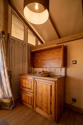 a kitchen with a wooden cabinet in a room at Glamping Podere San Jacopo in Massa Marittima