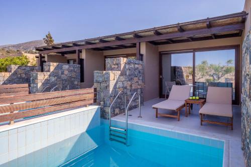 a house with a swimming pool and a patio at Blue Sea Beach Affiliated By Melia in Stalida