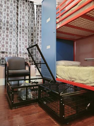 a bed and a chair in a room with a bunk bed and a chair istg at Orange Village Hostel in San Francisco