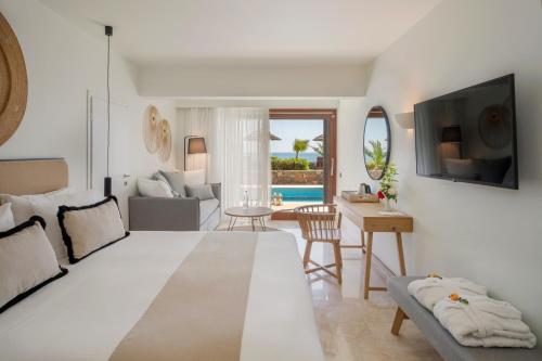 a living room with a large bed and a table at Blue Sea Beach Affiliated By Melia in Stalida