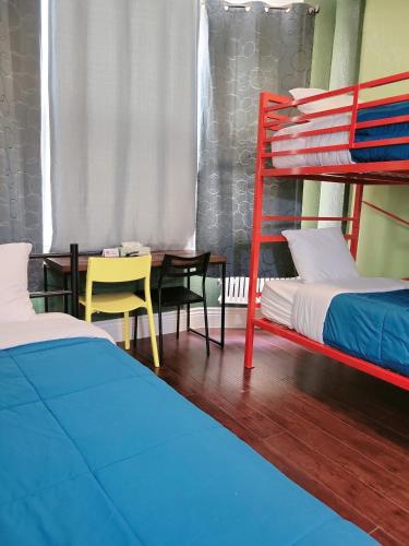 a bedroom with two bunk beds and a table at Orange Village Hostel in San Francisco
