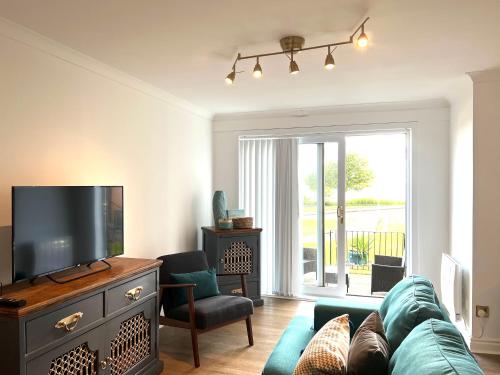 a living room with a couch and a tv at Bellevue Apartment in Largs