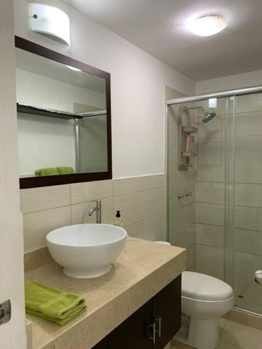リマにあるLovely two bedroom apartment in Mirafloresの洗面台、トイレ、鏡のあるバスルーム