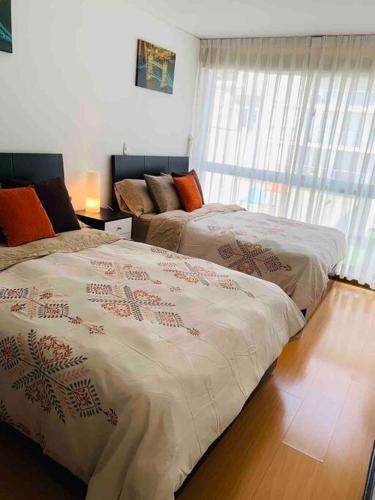 リマにあるLovely two bedroom apartment in Mirafloresのベッド2台と窓のある寝室