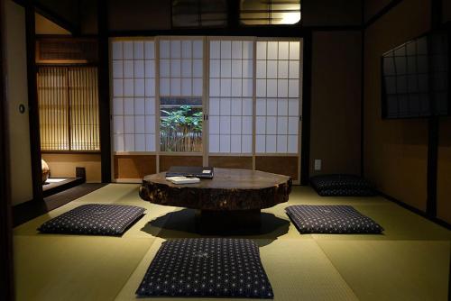 a room with a table and two mats on the floor at Reikaku Kiyomizu Gojo in Kyoto