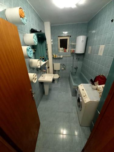 a bathroom with a toilet and a sink and a washing machine at Apartment Tarik in Sarajevo