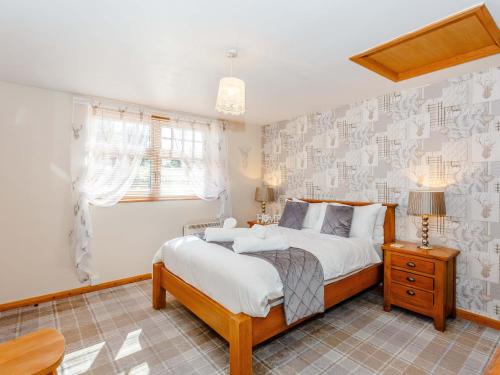 a bedroom with a large bed and a window at Ivy Cottage in Ripon