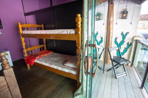 a room with a bunk bed and a chair at Suites Malibu in Arraial do Cabo
