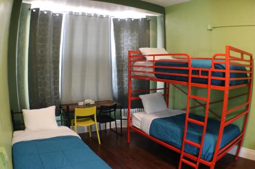 a room with two bunk beds and a table at Orange Village Hostel in San Francisco