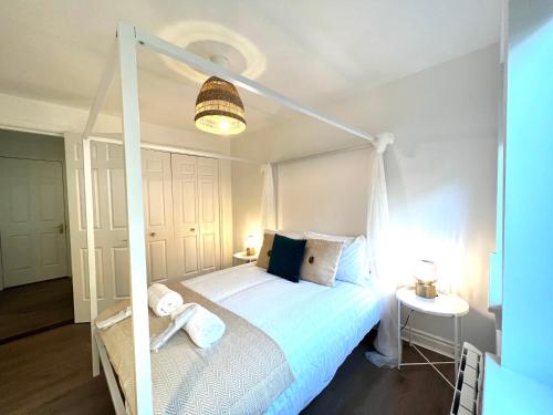 Bellevue Apartment في لارغس: غرفة نوم بسرير أبيض مع مظلة بيضاء