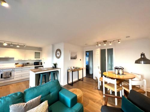 a living room with a green couch and a table at Bellevue Apartment in Largs