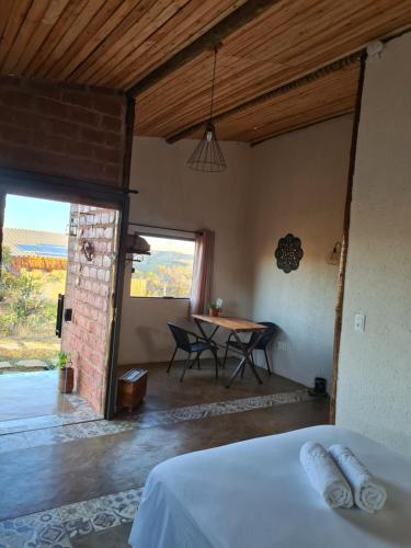 ein Schlafzimmer mit einem Bett und einem Tisch in einem Zimmer in der Unterkunft Rancho da Montanha Cipó in Serra do Cipo