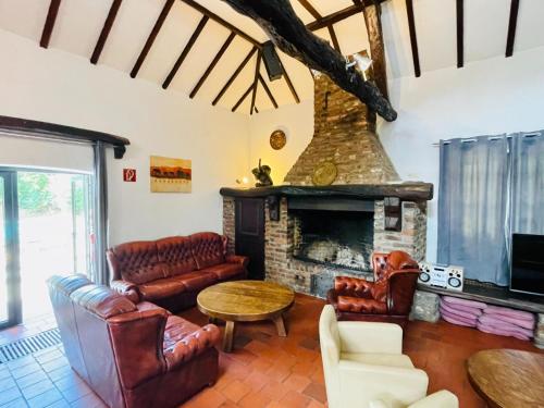 a living room with a fireplace and leather furniture at Magnificent Farmhouse in Sint Joost in Sint Joost