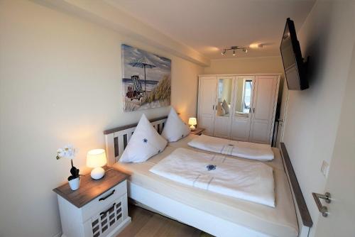 ホーヴァハトにあるMeeresblick-Strandparadies-Haus-3-WE-37の小さなベッドルーム(白いシーツ付きのベッド1台付)
