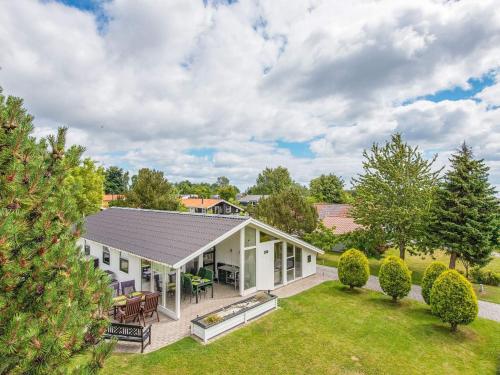 an exterior view of a white house with a yard at 8 person holiday home in Juelsminde in Sønderby