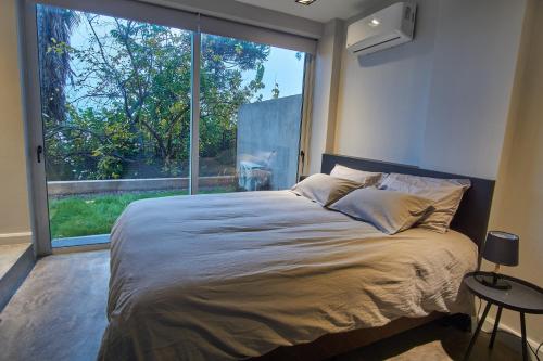 1 dormitorio con cama grande y ventana grande en Barrancas de Nieva B04 en San Salvador de Jujuy