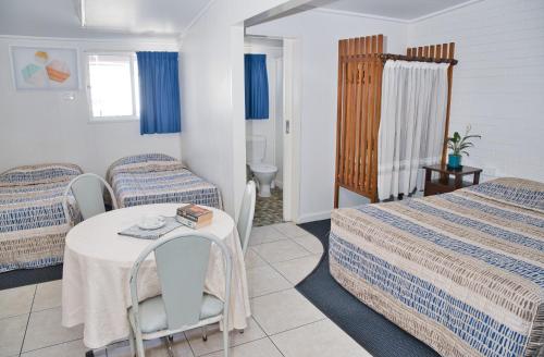 a hotel room with two beds and a table at Motel Myall in Dalby