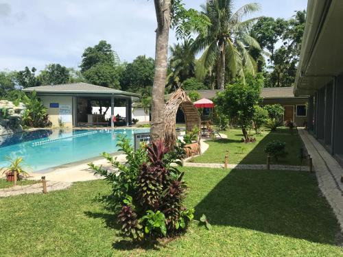 a resort yard with a swimming pool and a house at Hidden Lagoon Resort in Panglao