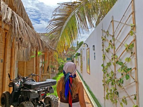 a woman standing next to a motorcycle next to a building at Puerto Bamboo in Máncora