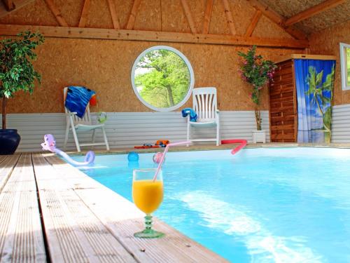 - une piscine avec une boisson sur une table en bois dans l'établissement Gîte de charme avec piscine couverte, sauna et bain nordique en pleine nature - FR-1-489-255, à Vernusse