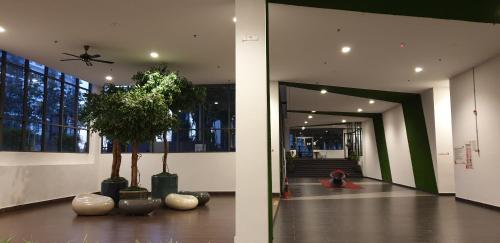 a hallway with two palm trees in a building at BSP21 Family Homestay in Jenjarum